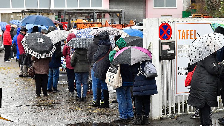 Menschen warten vor einer Essensausgabe. Fast zwei Drittel der erwachsenen Armen gingen entweder einer Arbeit nach oder waren in Rente oder Pension, heißt es.