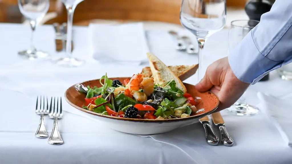 Ein-Kellner-serviert-einen-Salatteller-in-einem-Restaurant