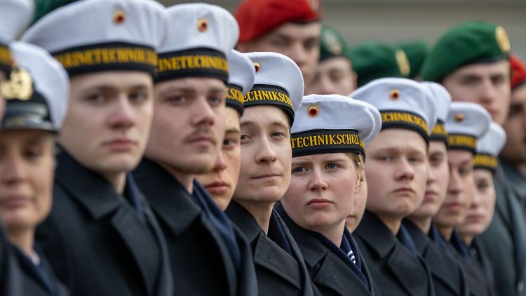 Bundeswehrrekruten und -Rekrutinnen stehen in Reih und Glied beim feierlichen Gelöbnis einer Vereidigungs-Zeremonie. 