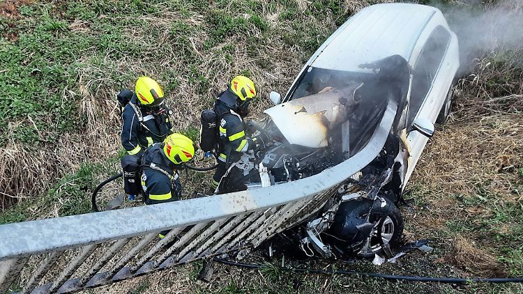 Feuerwehrleute löschen den Pkw-Brand nach dem schweren Unfall in der Steiermark.