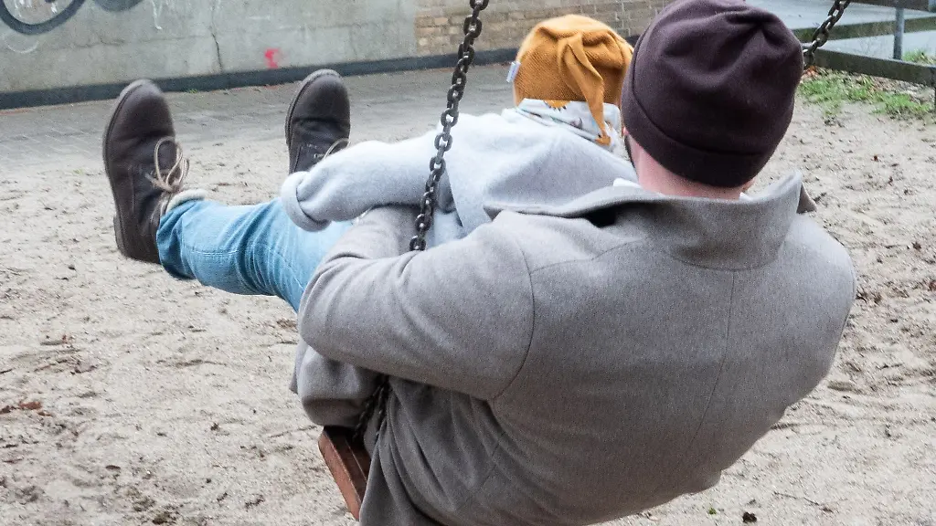 Ein-Vater-mit-seinem-Kind-auf-einem-Spielplatz-Paare-sollen-zwar-weiterhin-zusammen-bis-zu-14-Monate-Elternzeit-nehmen-koennen-aber-nur-noch-maximal-einen-Monat-parallel