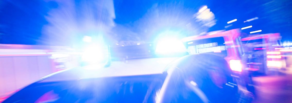 Ein Streifenwagen der Polizei steht mit Blaulicht an einem Einsatzort.