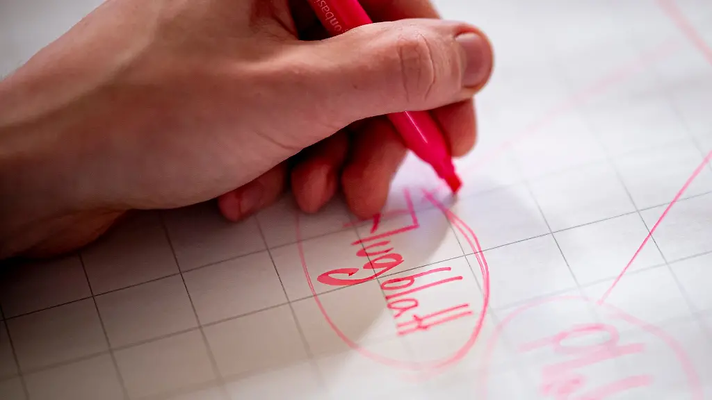 Ein-Schueler-einer-Sekundarschule-mit-gymnasialer-Oberstufe-schreibt-bei-einem-Workshop-zur-demokratischen-Beteiligung-von-Jugendlichen-Flugblatt-auf-ein-grosses-Blatt-Papier