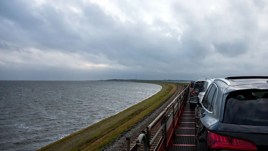 Ein-Autozug-der-Deutschen-Bahn-faehrt-ueber-den-Hindenburgdamm-auf-die-Nordseeinsel-Sylt