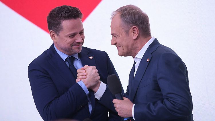 Rafal Trzaskowski (l.) von der zentristischen Bürgerkoalition bleibt Bürgermeister Warschaus. Ministerpräsident Donald Tusk (r.) gratuliert ihm.