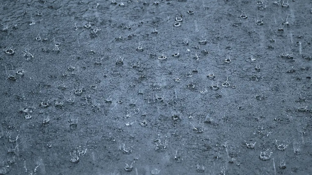 Regen-prasselt-waehrend-eines-Gewitters-auf-eine-Strasse