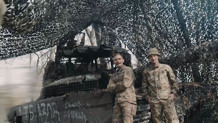Soldaten der Brigade Asow vor dem erbeuteten Anti-Drohnen-Panzer. 