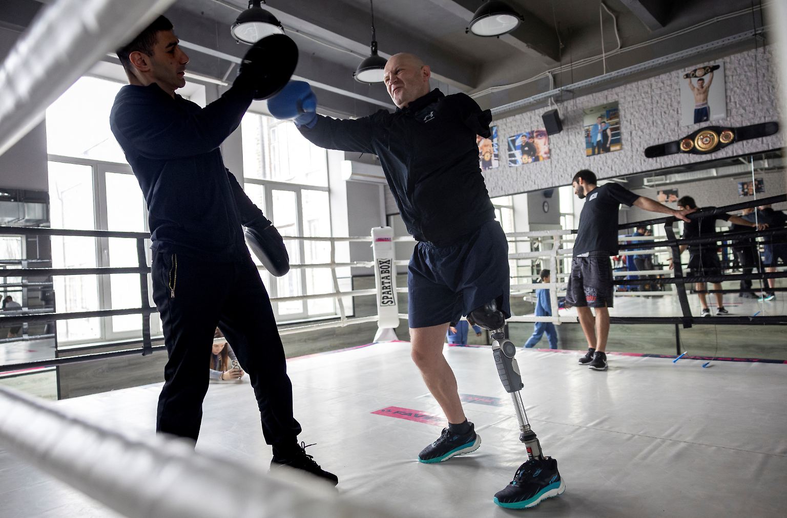 Oleksandr Revtiukh steht im Ring eines Fitnessstudios in Kiew und landet einen harten Haken auf dem Handschuh seines Trainers.