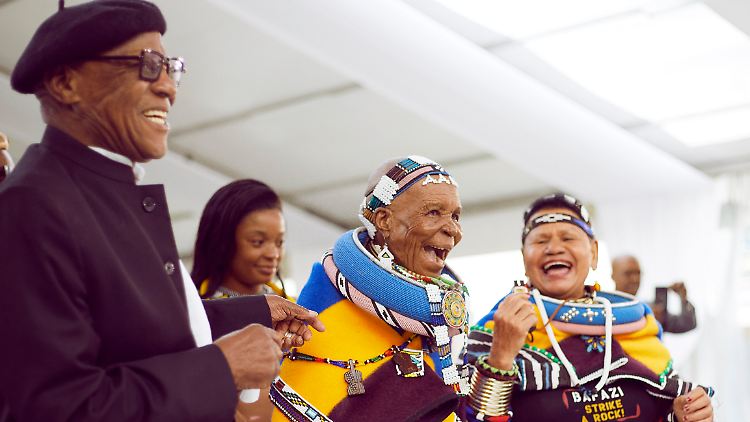 Fröhlich tanzend eröffnet Esther Mahlangu (Mitte) ihre Retrospektive in Kapstadt.