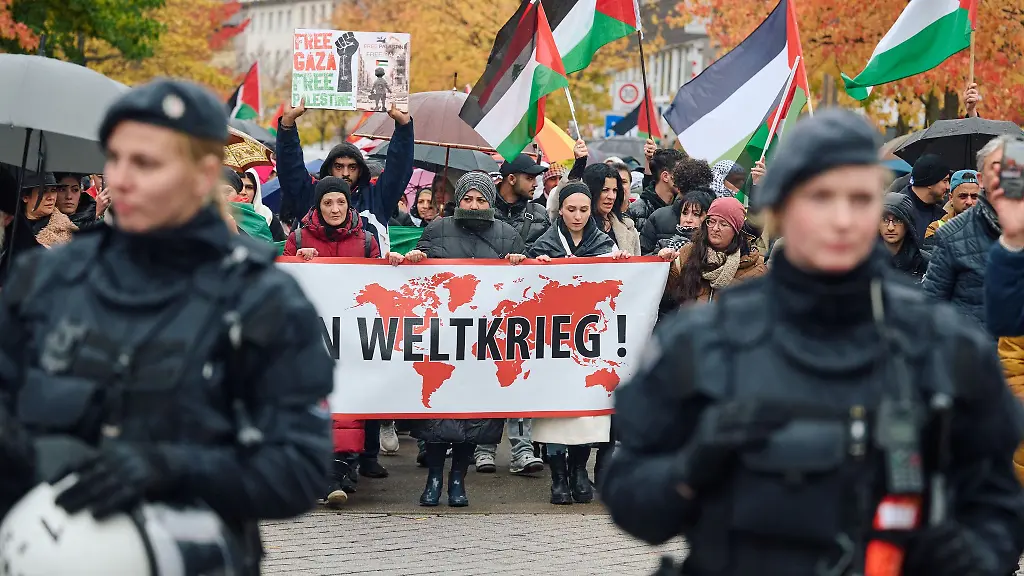 Teilnehmer-einer-Propalaestinensische-Demonstration-schwenken-Fahnen-und-zeigen-Plakate