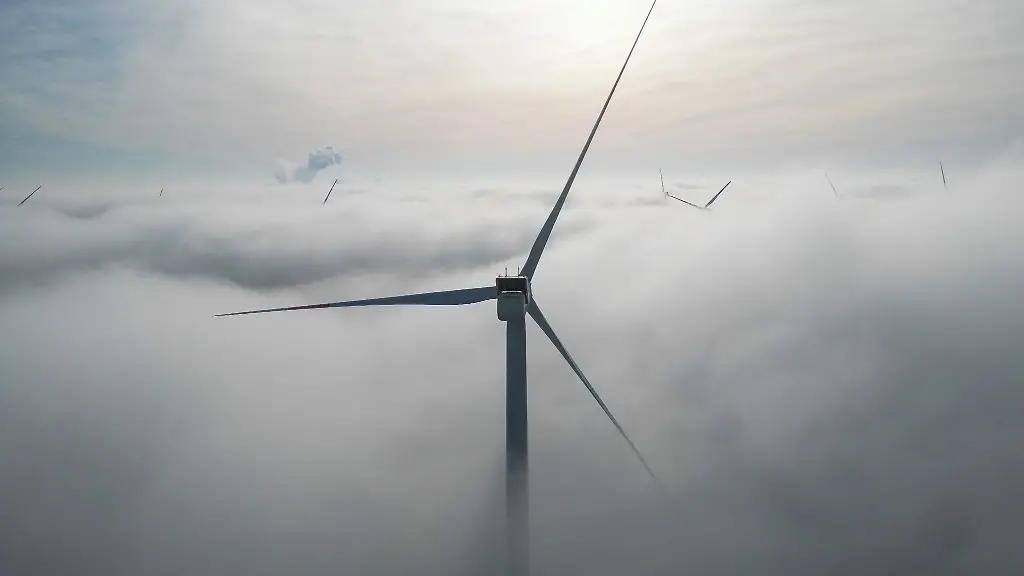 Die-Windraeder-in-einem-Windpark-westlich-von-Halle-ragen-aus-dem-Morgennebel-hervor