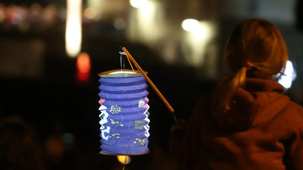 Ein-Maedchen-mit-einer-Laterne-steht-bei-einer-Martinsfeier-auf-dem-Domplatz