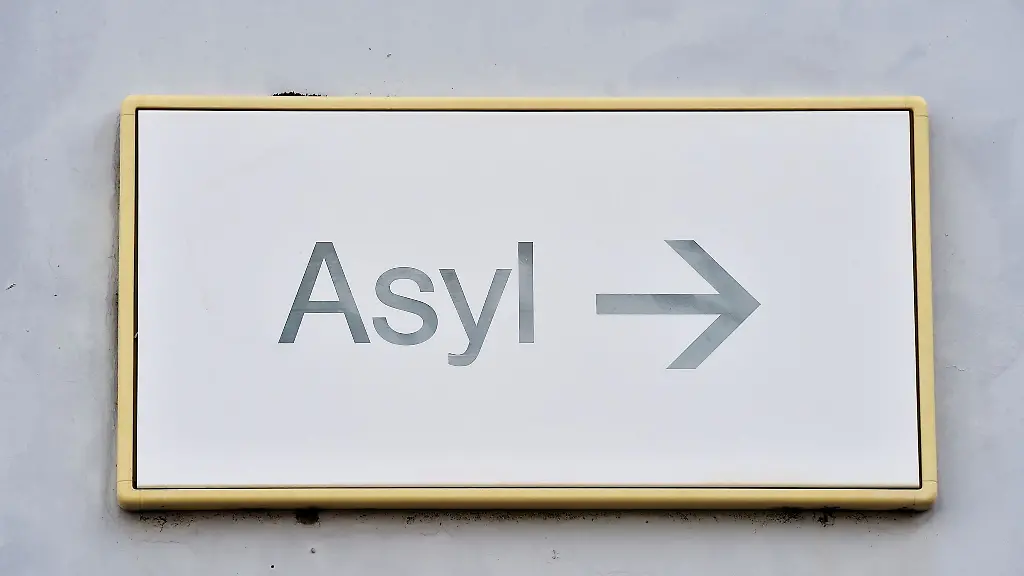 Ein-Schild-mit-der-Aufschrift-Asyl-haengt-an-einer-Wand
