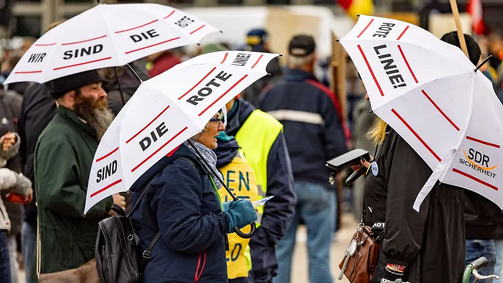 Teilnehmer-einer-Demonstration-der-Kieler-Gelbwesten-tragen-auf-dem-Kieler-Wilhelmsplatz-Regenschirme