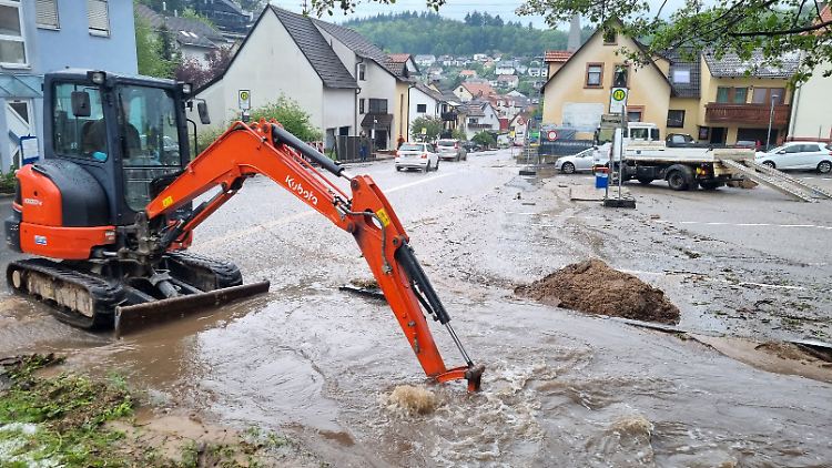In Schriesheim versucht ein Bagger, den örtlichen Bach freizuschaufeln, damit das Regenwasser besser abfließen kann.