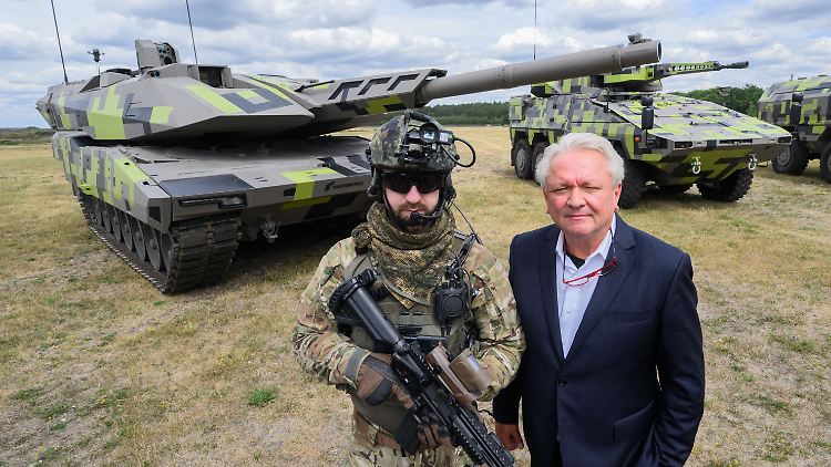 Rheinmetall-Chef Papperger (rechts) und ein "Infanterist der Zukunft" stehen vor einem Kampfpanzer Panther KF51 des Rüstungskonzerns.