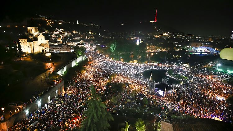 Demonstranten leuchten während eines Protests gegen das geplante Gesetz mit ihren Smartphones.