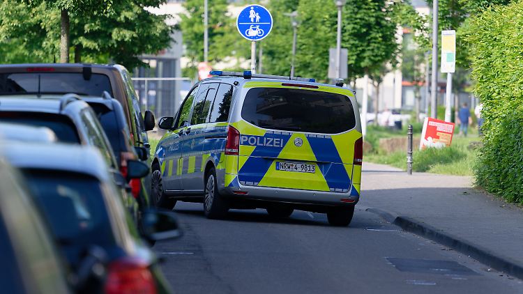 Ein Polizeiauto steht in einer Straße am Rand des Bürgerparks in Köln-Kalk.