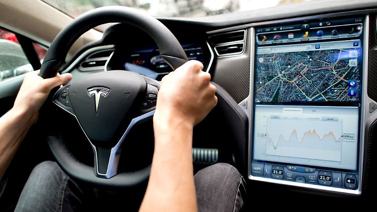 Ein Mann sitzt in einem Tesla Model S am Lenkrad: Elon Musk sagt, er sei mit seinen Versprechen zu selbstfahrenden Autos oft zu optimistisch gewesen.