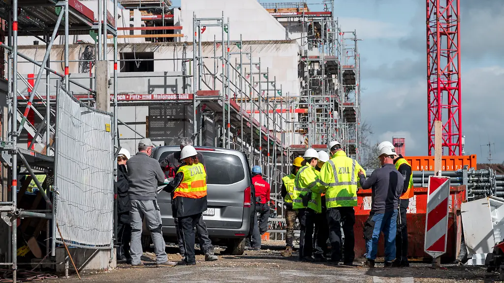 Einsatzkraefte-des-Zolls-befragen-Arbeiter-auf-einer-Baustelle-Unter-anderem-wird-geprueft-ob-eine-illegale-Beschaeftigung-besteht-oder-die-Arbeitserlaubnis-der-Arbeitnehmer-vorliegt