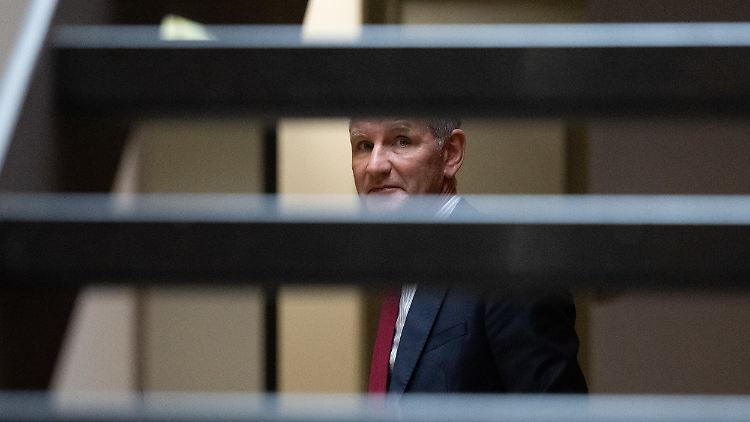 Björn Höcke im Justizzentrum zu Halle, fotografiert durch die Stufen einer Treppe.