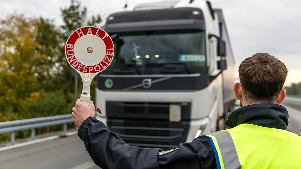 Ein-Beamter-der-Bundespolizei-stoppt-einen-Lkw-an-der-Autobahn-A15-an-der-Grenze-zwischen-Polen-und-Deutschland-Seit-dem-16-Oktober-finden-voruebergehend-stationaere-Binnengrenzkontrollen-fuer-die-Grenzen-zu-Polen-Tschechien-und-der-Schweiz-statt