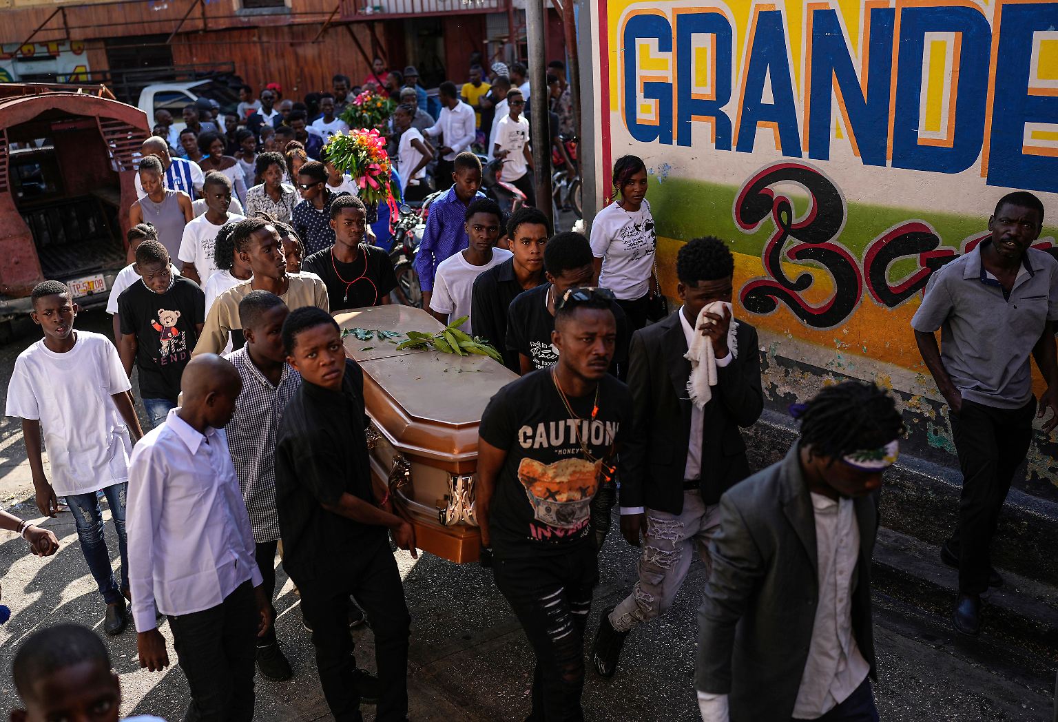 Vor einem Friedhof in der haitianischen Hauptstadt Port-au-Prince steht eine Gruppe Jugendlicher. 