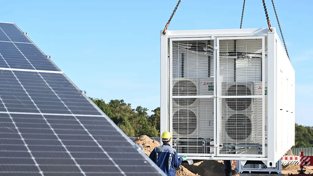 An-einem-Solarpark-werden-zwei-Batteriespeicher-angeliefert