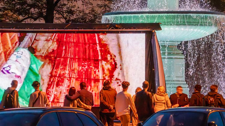 Am 7. Oktober verübte die Hamas ein grausames Massaker in Israel. Originalaufnahmen davon werden bei einer Aktion in München auf einem großen Videoschirm gezeigt.  
