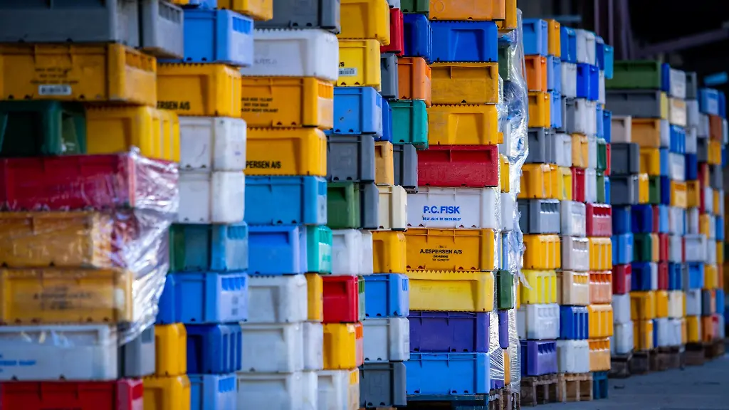 Leere-Fischkisten-stehen-hinter-einem-Kuehlhaus-am-Fischereihafen