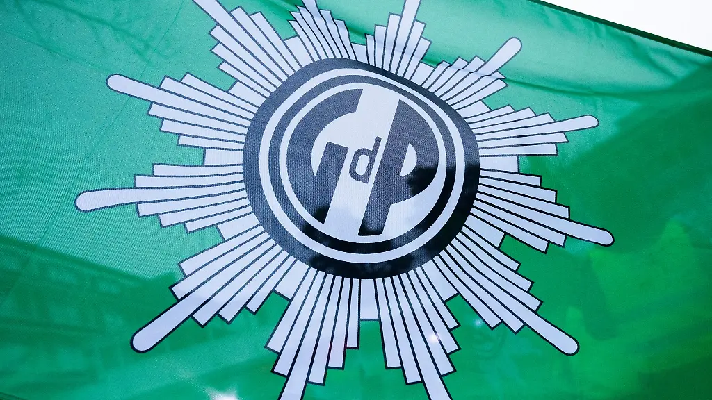 Bei-einer-Kundgebung-waehrend-eines-Tarifkonflikts-im-Oeffentlichen-Dienst-weht-eine-Flagge-mit-dem-Logo-der-Gewerkschaft-der-Polizei-GdP