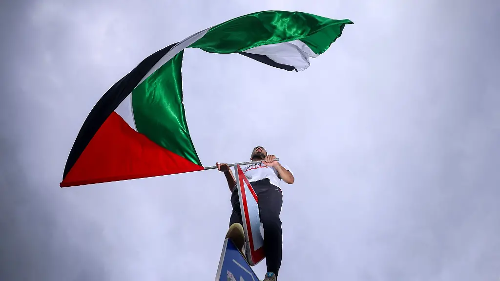 Ein-Mann-schwenkt-eine-palaestinensische-Fahne-waehrend-einer-pro-palaestinensischen-Demonstration