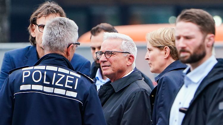 Baden-Württembergs Innenminister Thomas Strobl spricht nach dem Messerangriff in Mannheim mit Einsatzkräften am Tatort.