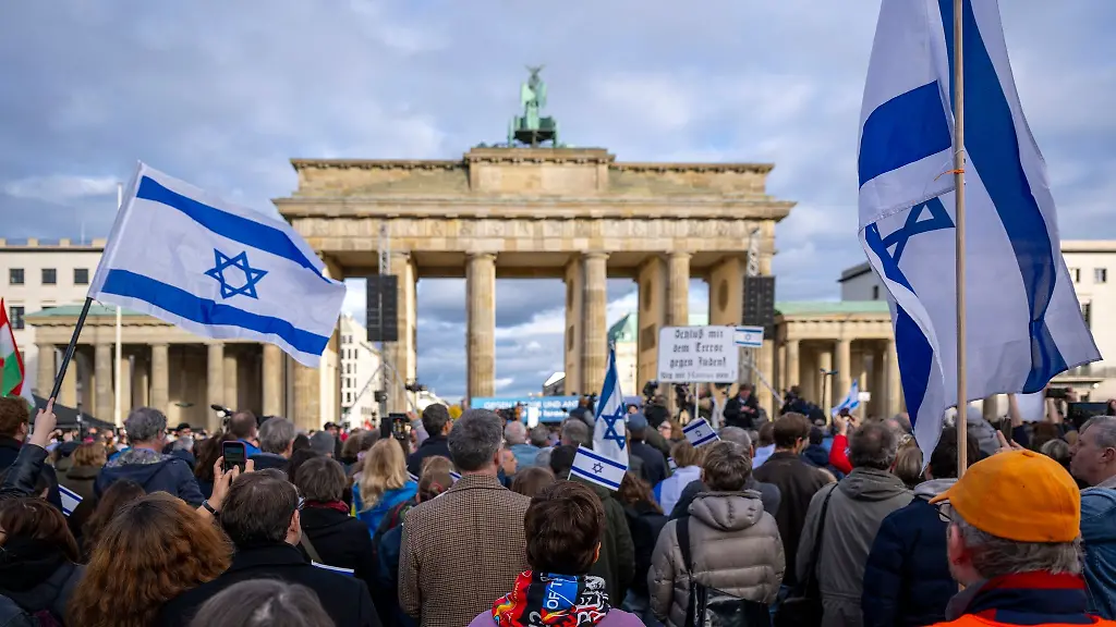 Teilnehmer-der-Kundgebung-Aufstehen-gegen-Terror-Hass-und-Antisemitismus-in-Solidaritaet-und-Mitgefuehl-mit-Israel-vor-dem-Brandenburger-Tor-schwenken-israelische-Flaggen