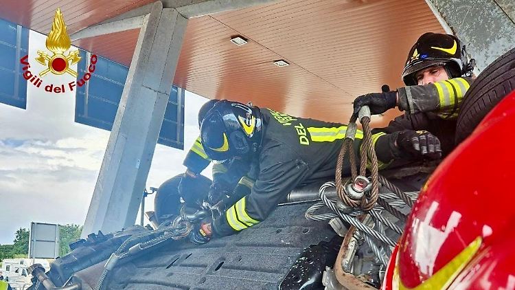 Einsatzkräfte der Feuerwehr untersuchen Autos nach dem schweren Verkehrsunfall. 
