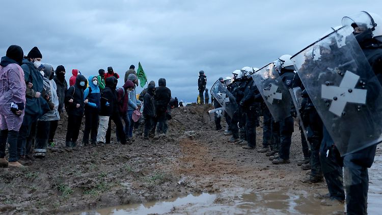 Polizisten und Aktivisten stehen sich im Januar 2023 bei einer Demonstration am Rande des Braunkohletagebaus bei Lützerath gegenüber.