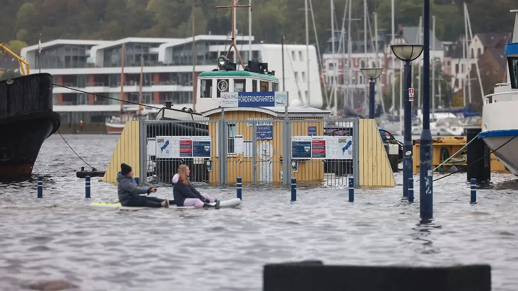 Zwei-Personen-paddeln-auf-einem-Stand-Up-Padle-Board-ueber-das-Wasser-am-Hafen