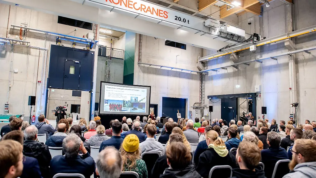 Mitarbeiterinnen-und-Mitarbeiter-des-Alfred-Wegener-Instituts-sitzen-in-einer-Halle-des-neuen-Technikums