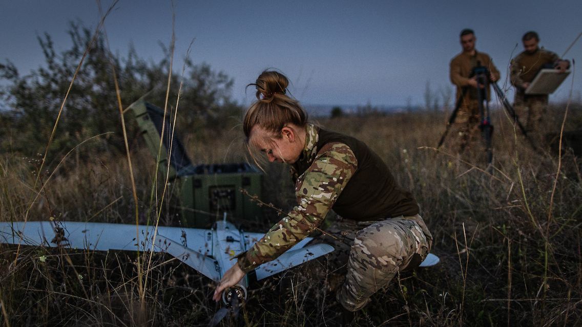Eine ukrainische Soldatin montiert eine Drohne vor einer Übung.