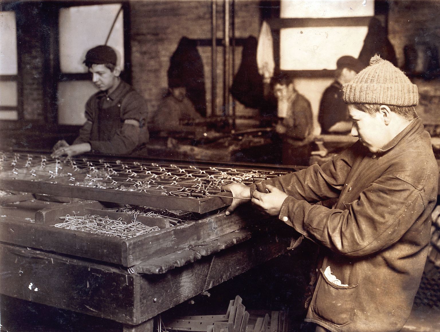Beim Stichwort Kinderarbeit haben viele Bilder wie dieses vor Augen. Im 19. Jahrhundert bauen Jungen im US-Bundesstaat Massachusetts Bettfedern zusammen.