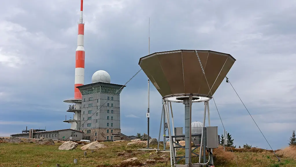 Dunkle-Wolken-ziehen-ueber-den-Brocken-und-die-Messinstrumente-der-Wetterwarte