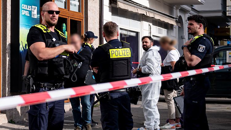 Polizisten sind vor dem Haus in Charlottenburg-Wilmersdorf im Einsatz, in dem das Opfer gefunden wurde.