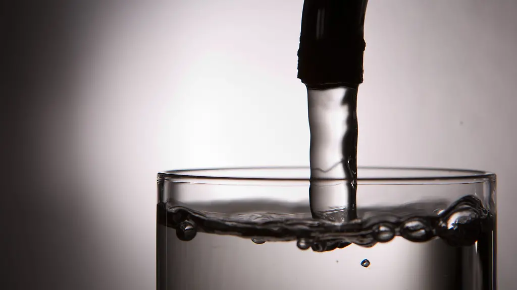 Leitungswasser-laeuft-aus-einem-Wasserhahn-in-ein-Glas