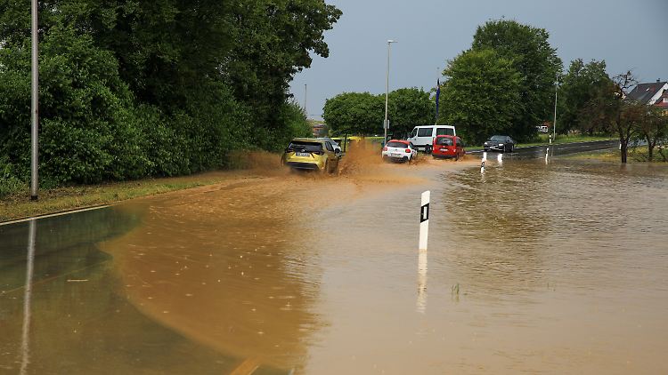 Mehrere Autos kämpfen sich auf einer überschwemmten Straße bei Burgstetten voran.