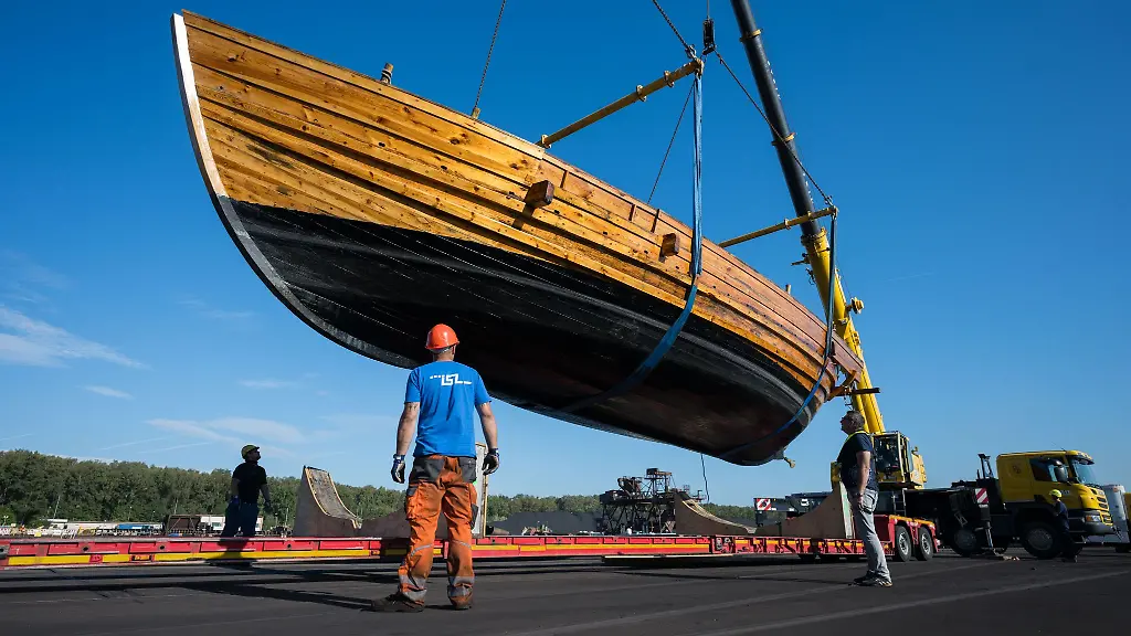 Der-Nachbau-eines-alten-roemischen-Handelsschiffes-Bissula-von-Forschern-der-Universitaet-Trier-wird-im-Saarhafen-auf-einen-Schwerlasttransporter-geladen