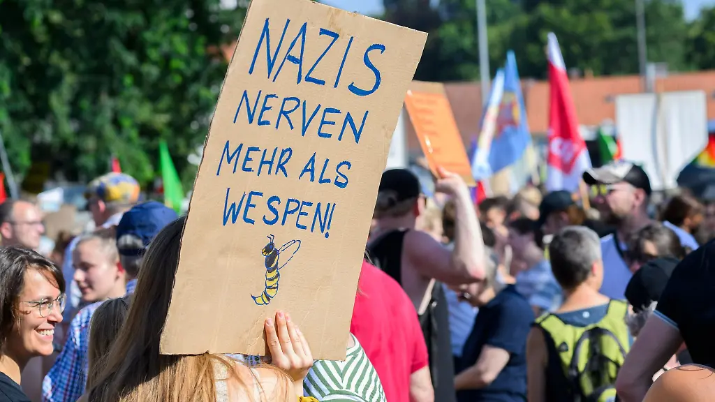 Demonstranten-halten-ein-Plakat-mit-Aufschrift-Nazis-nerven-mehr-als-Wespen