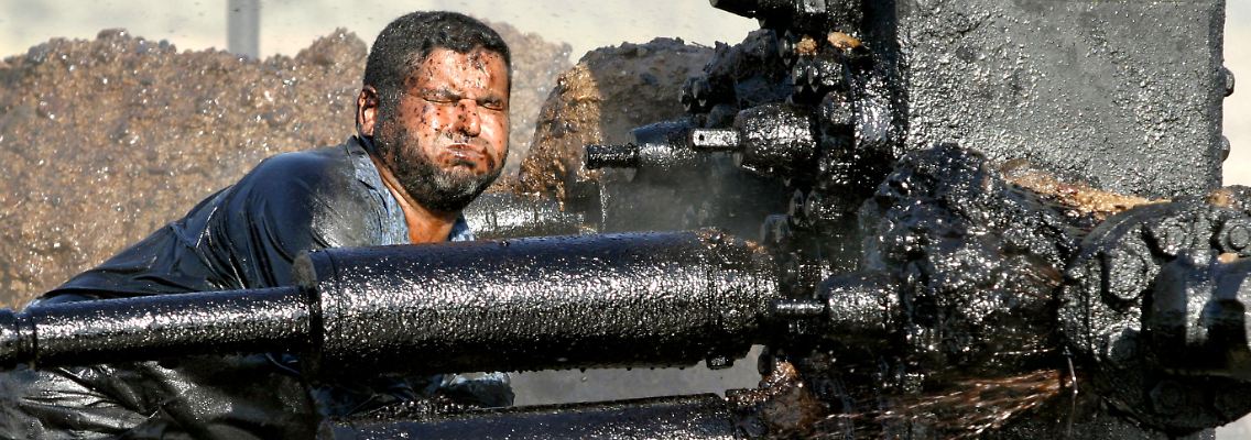 Ganz unten, wo das Öl aus dem Boden kommt, zeigt die Branche ihre Schattenseiten: Im Irak versucht ein Arbeiter, eine defekte Ölpumpe abzudichten.
