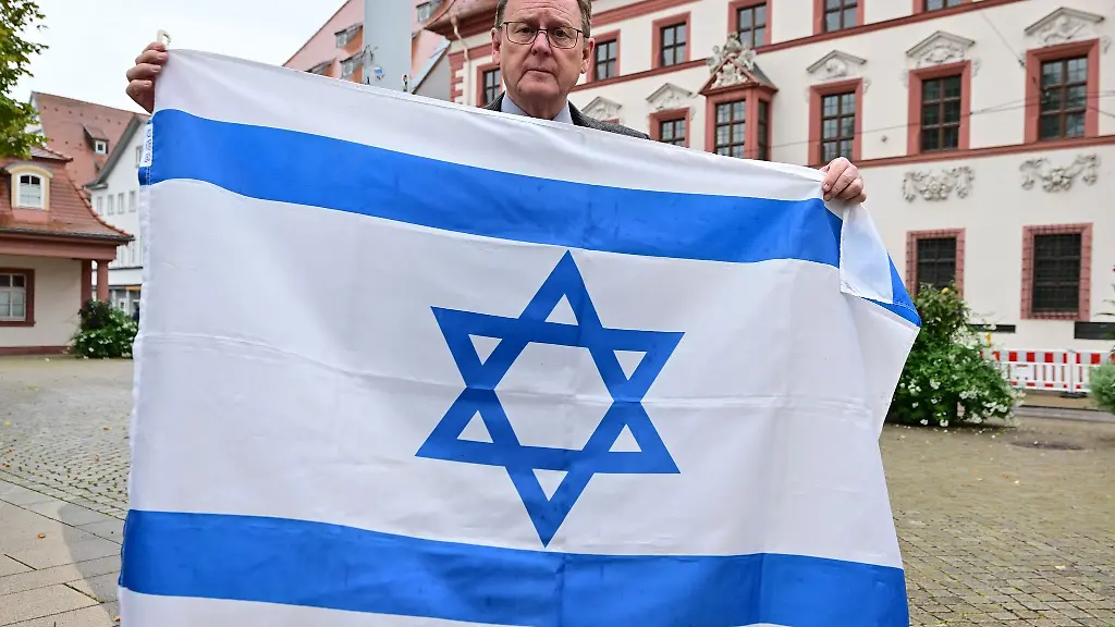 Bodo-Ramelow-Die-Linke-Ministerpraesident-von-Thueringen-haelt-eine-israelische-Flagge-vor-der-Thueringer-Staatskanzlei