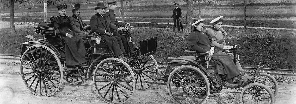 01_Benz_Velo__rechts__und_Benz_Phaeton__links__bei_einer_UEberlandtour_1895_-_am_Lenkrad_des_Velo_ist_Clara_Benz,_Tochter_von_Carl_Benz._Quelle_Mercedes-Benz_Classic_Archive.jpg