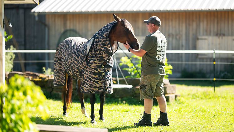 Mike, Hauptmann bei der Bundeswehr, steht mit einem Pferd auf der Silberburg-Ranch bei Aichhalden in Baden-Württemberg. 